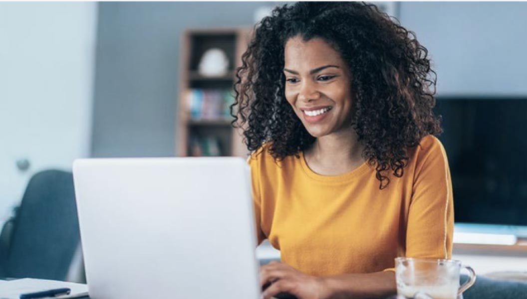 woman looking at a laptop, smiling